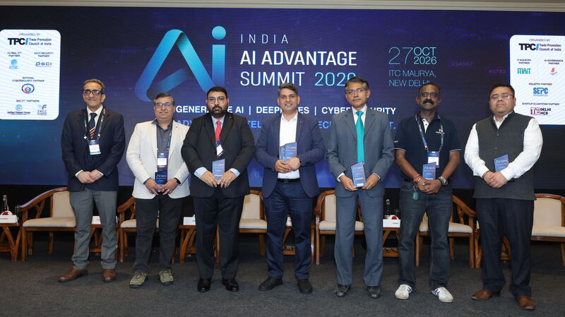 The seven panellists standing together on stage in front of the India AI Advantage Summit 2026 screen