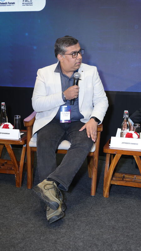 Dipender Bhamrah seated on stage, holding a microphone, at the India AI Advantage Summit 2026